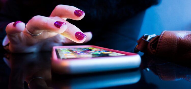 person using black smartphone with gray and pink case