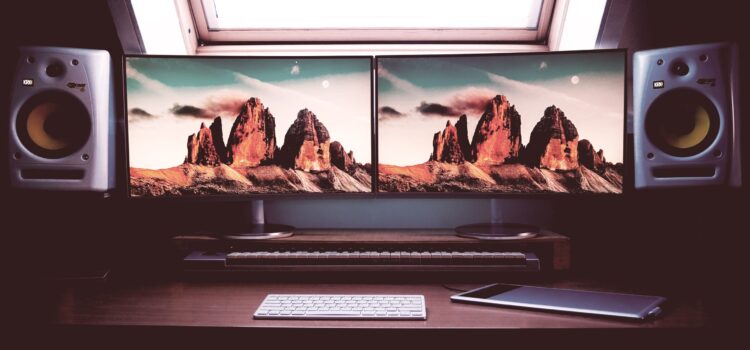 Handy Tips to Optimize a Dual-Monitor Setup for the Best Experience turned on two flat screen computer monitors with speakers
