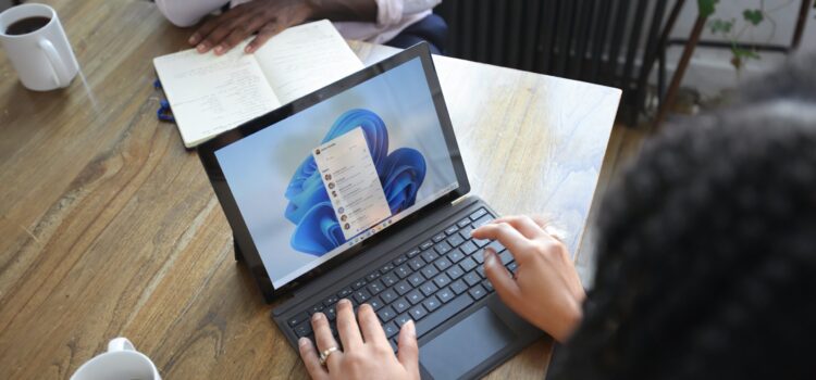 Workspaces, a VPN & More – Learn the Newest Microsoft Edge Features Overhead view of two people at a table working with a Microsoft laptop and notebook