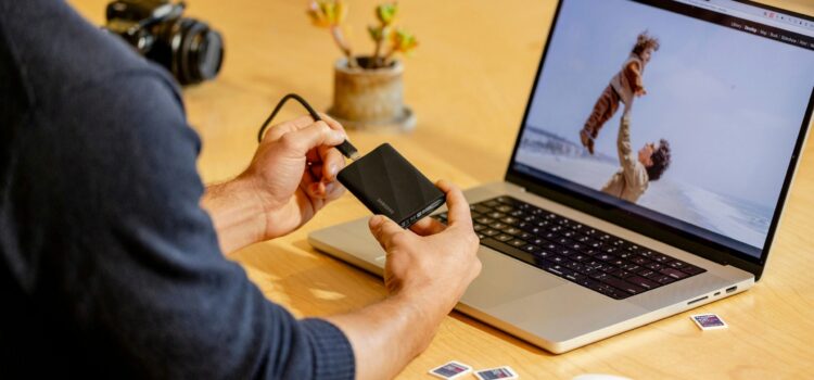 A man sitting at a table with a laptop and cell phone