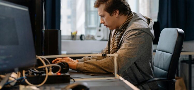 5 Microsoft 365 Settings Worth Checking in Your Tenant Free A concentrated professional working at a computer in a modern office setting. Stock Photo