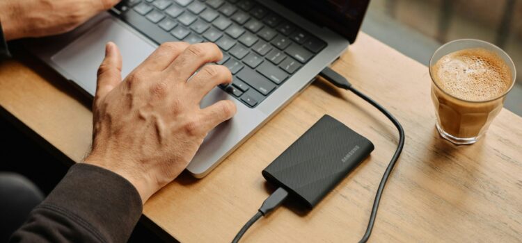 A man sitting at a table using a laptop computer