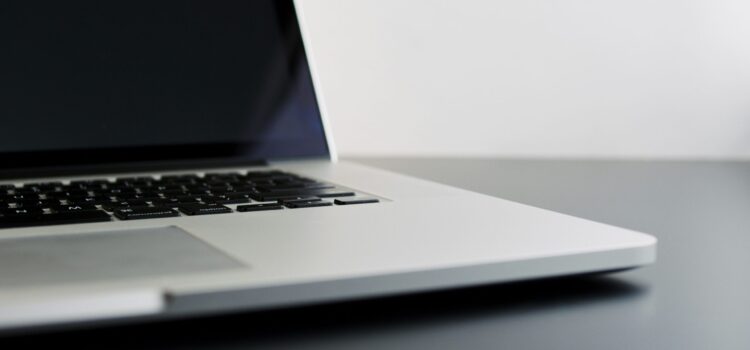 silver laptop computer on black table